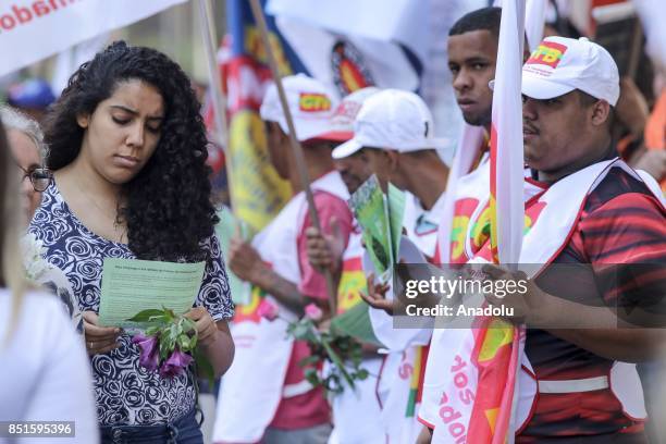 Woman receives flowers and a flyer during a demonstration organised by the Central of Brazil's Workers and the other trade union centrals with...