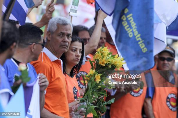 Demonstrators distribute flowers during a demonstration organised by the Central of Brazil's Workers and the other trade union centrals with...