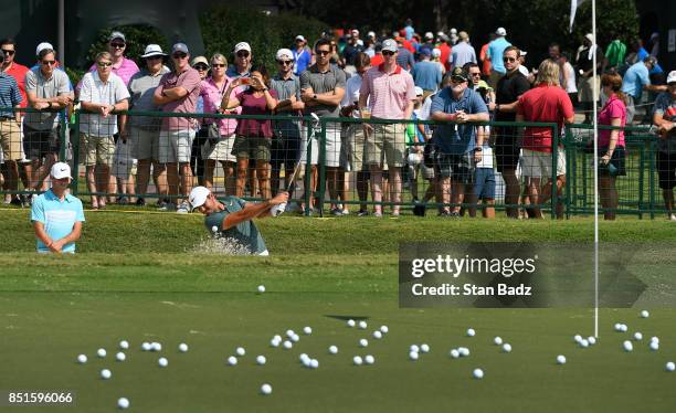 Fans watch Jason Day of Australia hit bunker shots before the second round of the TOUR Championship, the final event of the FedExCup Playoffs, at...