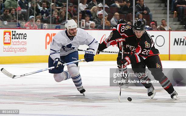 Antoine Vermette of the Ottawa Senators stickhandles the puck against Ian White of the Toronto Maple Leafs at Scotiabank Place on February 28, 2009...