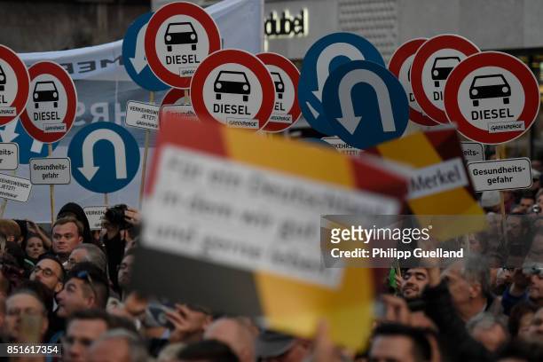 Greenpeace activists show signs referring to the diesel scandal appear at German Chancellor and Christian Democrat Angela Merkel's last big election...