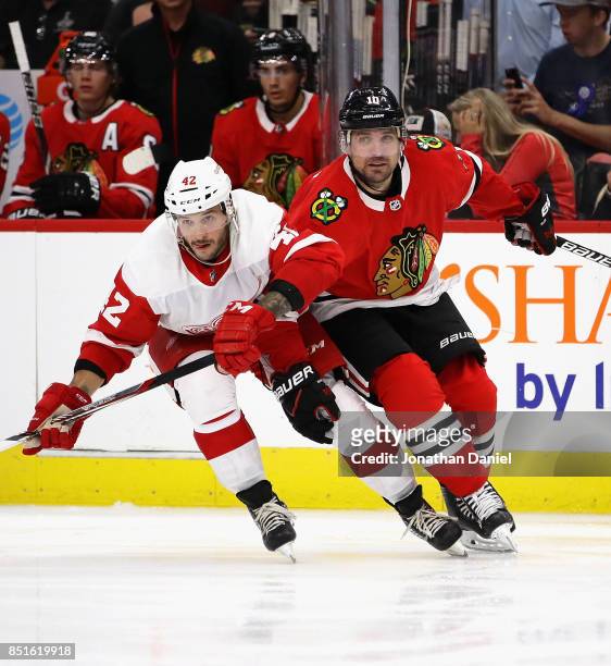 Patrick Sharp of the Chicago Blackhawks battles for position with Martin Frk of the Detroit Red Wings during a preseason game at the United Center on...