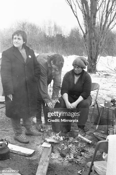 Women huddle together around camp fires in the 'Women's Peace Camp' at Greenham Common following a heavy snowfall 12th January 1987.