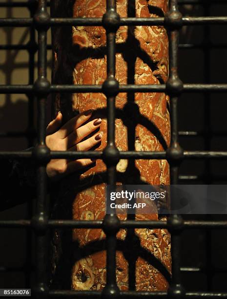 Beliver touches an ancient column inside the crypt of Saint Nicholas church on March 1, 2009 in Bari. Italian President Giorgio Napolitano presents...