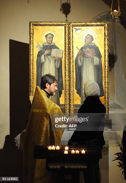 Orthodox Protopresbyter Vladimir listens to a beliver at Saint Nicholas' church on March 1, 2009 in Bari. Italian President Giorgio Napolitano...