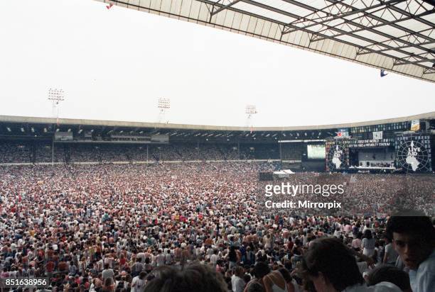 Live Aid concert held at Wembley Stadium, London to raise funds for relief of the ongoing Ethiopian famine. View of the huge crowd of around 72,000...