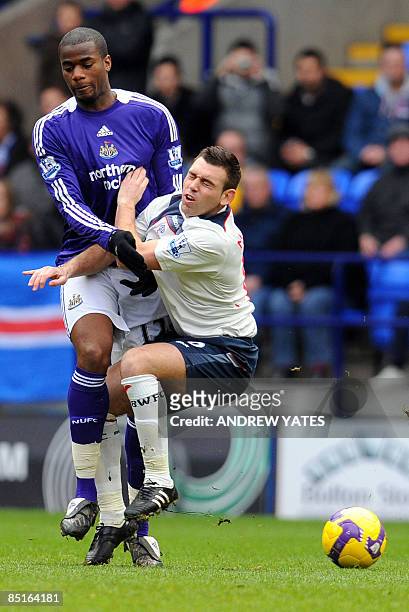 Bolton Wanderers English forward Mark Davies is blocked by Newcastle United's Sebastien Bassong during the English Premier league football match at...