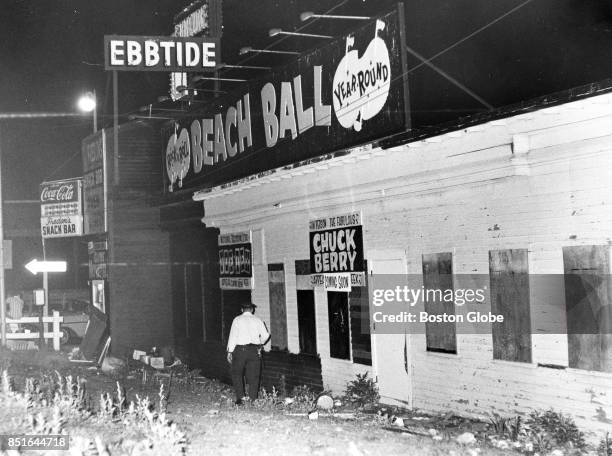 Policeman searches the grounds outside "Beach Ball" nightclub looking for the gun used in the shooting near Revere Beach on June 17, 1967.