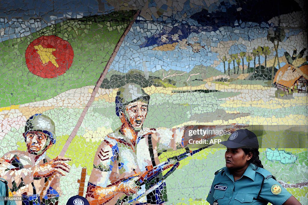 A Bangladeshi policewoman stands beside