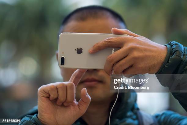 Customer views an Apple Inc. IPhone 8 smartphone during the sales launch of the Apple Inc. IPhone 8 smartphone, Apple watch series 3 device, and...