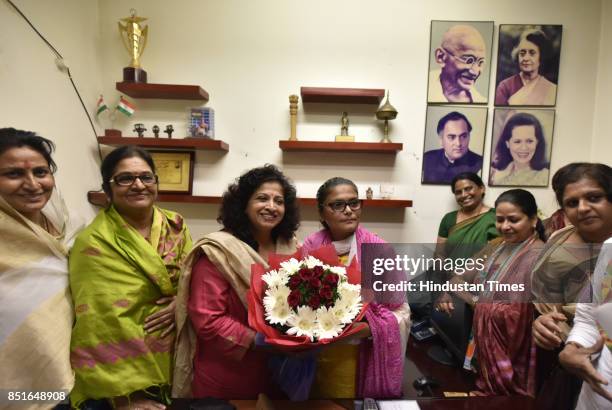 Outgoing President of Mahila Congress Shobha Oza offers flowers to new President of Mahila Congress Silchar MP Sushmita Dev at the AICC on September...