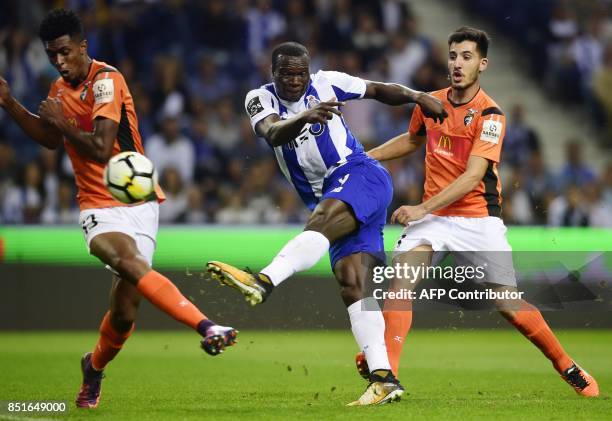 Porto's Cameroonian forward Vincent Aboubakar kicks the ball between Portimonense's Brazilian defender Felipe Macedo and midfielder Pedro Sa to score...