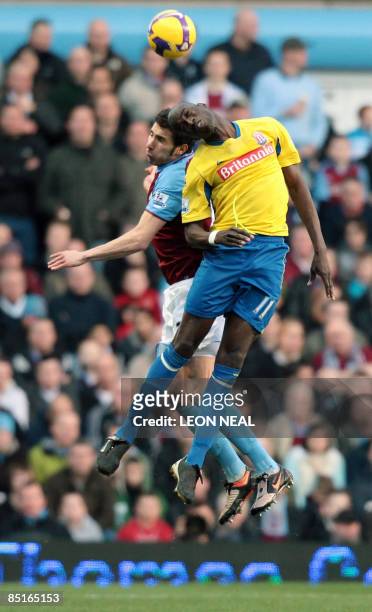Aston Villa's Spanish player Carlos Cuellar and Stoke City's Malian footballer Mamady Sidibe leap for the ball during a Premiership match at Villa...