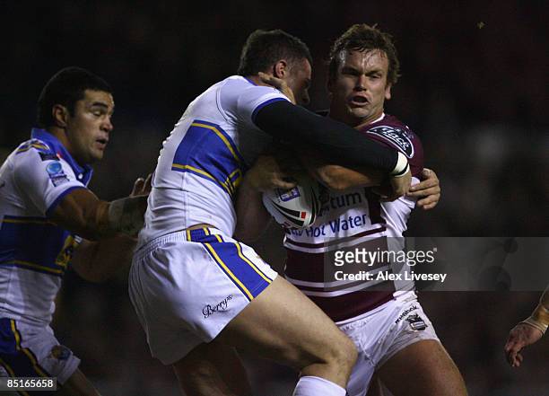 Josh Perry of Manly Sea Eagles is tackled by Ian Kirke of Leeds Rhinos during the Carnegie World Club Challenge match between Leeds Rhinos and Manly...