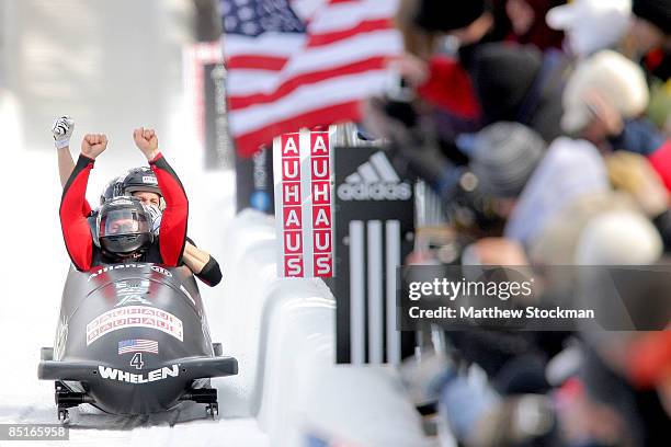 Members of USA 1, piloted by Steven Holcomb, celebrate after crossing the finish line to win the four man competition during the FIBT Bobsled World...