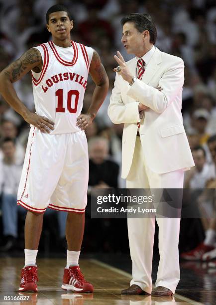 Rick Pitino the Head Coach of the Louisville Cardinals gives instructions to Edgar Sosa during the Big East Conference game against the Marquette...