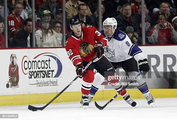 Kris Versteeg of the Chicago Blackhawks gets ready to pass the puck as Drew Doughty of the Los Angeles Kings comes up form behind at the United...