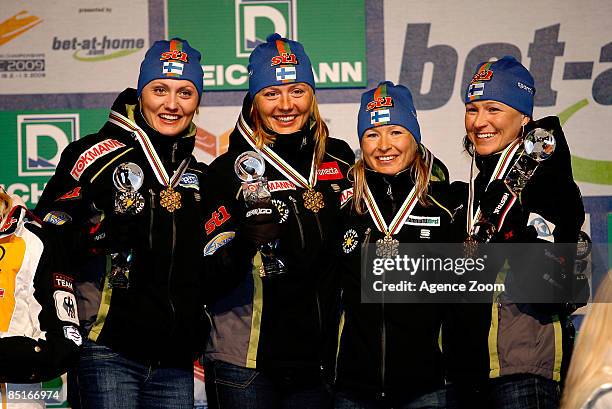 Finland team members Pirjo Muranen, Virpi Kuitunen, Riitta-Liisa Roponen and Aino-Kaisa Saarinen celebrate with their gold medals after winning the...