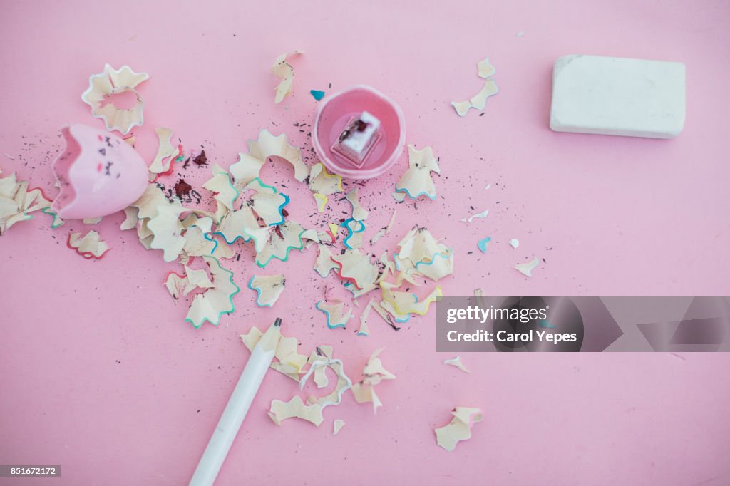 Pencil, pencil shavings and pencil sharpener in pink background