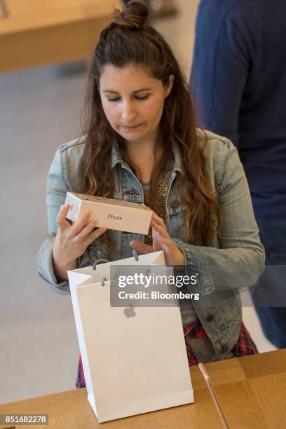 Customer removes an iPhone box from a shopping bag during the sales launch of the Apple Inc. IPhone 8 smartphone, Apple watch series 3 device, and...