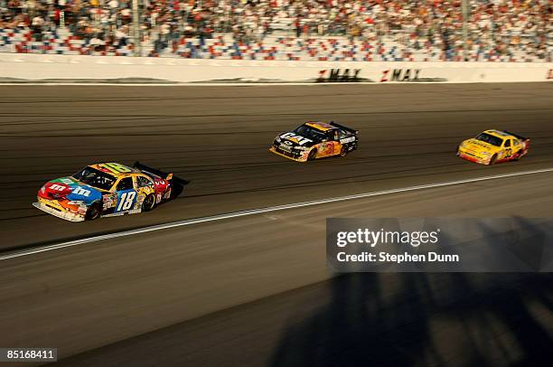 Kyle Busch driver of the M&M's Toyota leads Jeff Burton in the Caterpillar Chevrolet and Clint Bowyer in the Cheerios/Hamburger Helper Chevrolet...