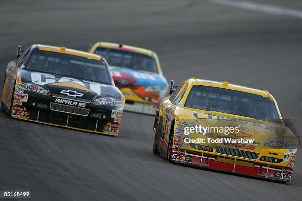 Clint Bowyer, driver of the Cheerios/Hamburger Helper Chevrolet, and Jeff Burton, driver of the Caterpillar Chevrolet, drive during the NASCAR Sprint...