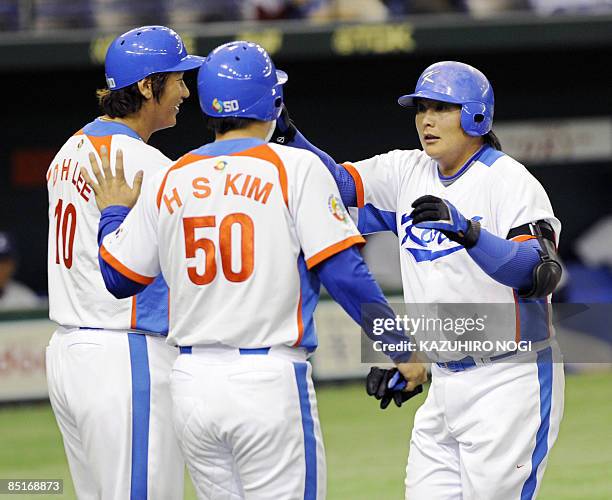 South Korean infielder Kim Tae-Kyun is congratulated by teammates Lee Dae-Ho and Kim Hyun-Soo after his two-run home run in the third inning against...