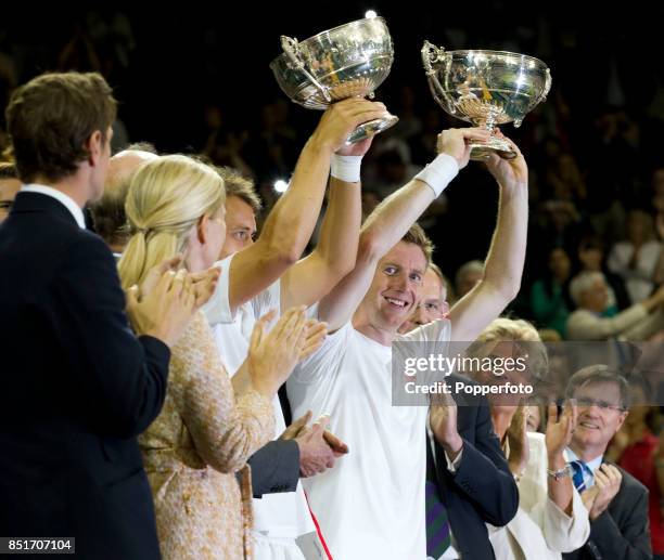 Jonathan Marray of Great Britain and Frederik Nielsen of Denmark lift their trophies after winning their Gentlemans Doubles final match against...