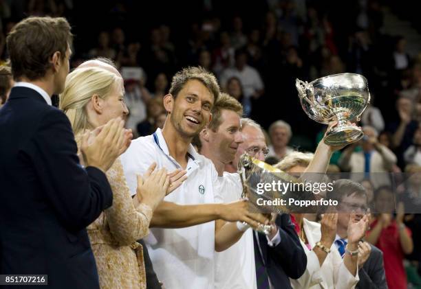 Jonathan Marray of Great Britain and Frederik Nielsen of Denmark lift their trophies after winning their Gentlemans Doubles final match against...