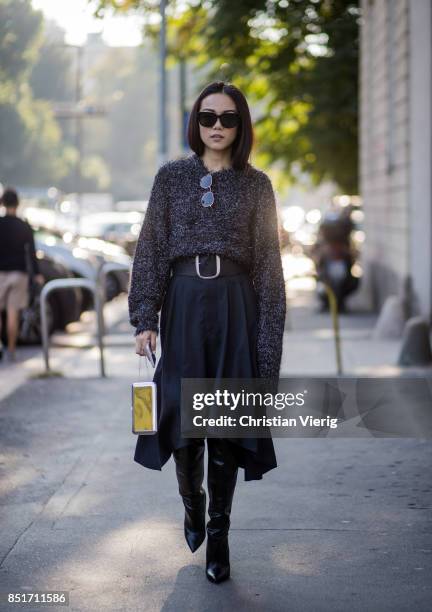 Yoyo Cao wearing a grey knit, navy midi skirt with belt, black overknee boots is seen outside Tods during Milan Fashion Week Spring/Summer 2018 on...