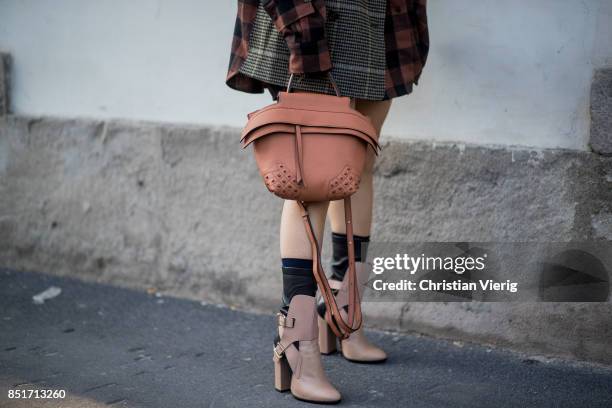 Yuwei Zhangzou wearing checked button dress, grey checked blazer, Tods bag, ankle boots is seen outside Tods during Milan Fashion Week Spring/Summer...