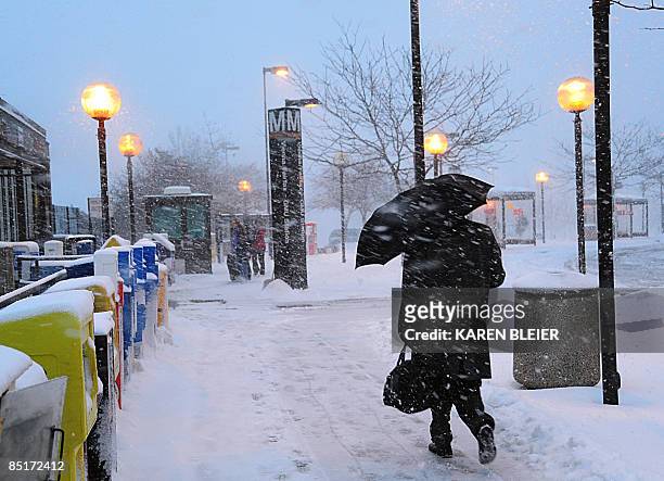 Man uses an umbrella to shield himself from driving snow on March 2, 2009 as he walks to a Metro train station in Vienna, Virgina. Massive snowstorm...