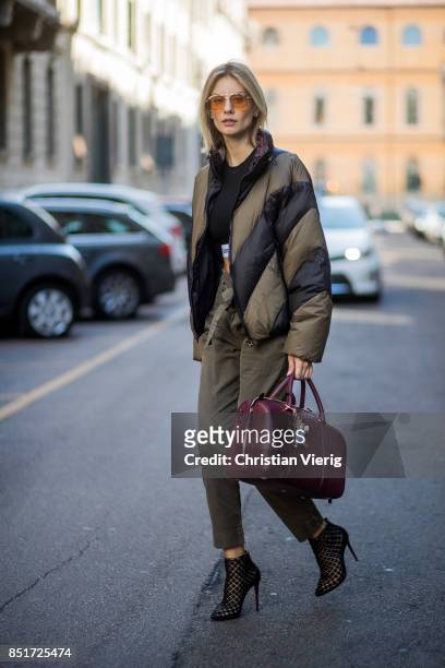 Lisa Hahnbueck wearing an olive Public School down feather jacket, Paco Rabane cropped tshirt, Frame denim pants, Christian Louboutin heels, MCM bag...