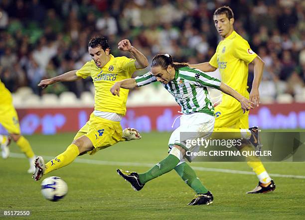 Betis's Sergio Garcia shoots and scores next to Villarreal's Diego Godin and Jose Joaquin Moreno during their Spanish league football match at Ruiz...