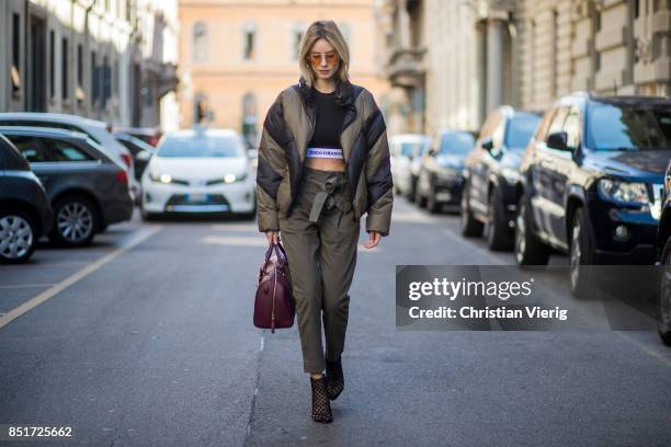 Lisa Hahnbueck wearing an olive Public School down feather jacket, Paco Rabane cropped tshirt, Frame denim pants, Christian Louboutin heels, MCM bag...