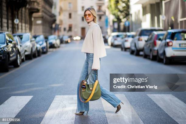 Lisa Hahnbueck wearing Golden Goose deluxe brand turtle neck, Citizens of Humanity jeans, MCM bag, MCM Charm, Balenciaga boots is seen during Milan...