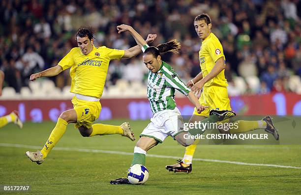 Betis's Sergio Garcia shots and scores next to Villarreal's Diego Godin and Jose Joaquin Moreno during their Spanish league football match at Ruiz de...