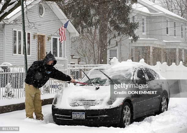 Man cleans the snow from his car March 2, 2009 in the Bronx Borough of New York City. Heavy snows created choas around the northeast United States....