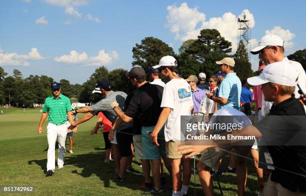 Jordan Spieth of the United States greets fans Adam Scott of Australia he walks from the 16th green during the second round of the TOUR Championship...