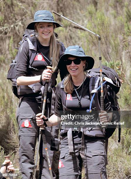 Fearne Cotton looks on as Denise Van Outen holds up a broken pole after falling over as they trek up Kilimanjaro on the second day of The BT Red Nose...