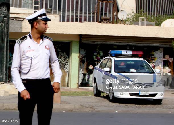 An Iraqi policeman stands in a street in the capital Baghdad on September 19, 2017. The tradition in Iraq is for many cases to be settled by tribal...