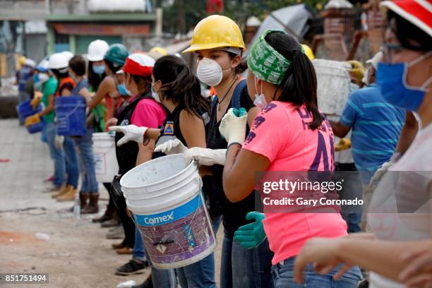 Volunteers remove rubble from the Neto supermarket where people were found deceased in the San Gregorio Atlapulco neighborhood of Delegacion...