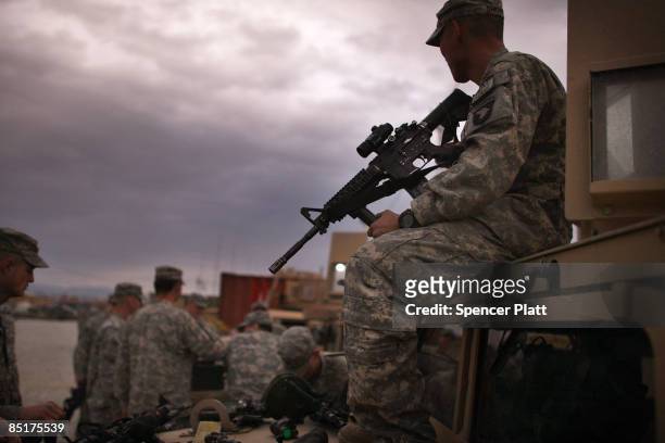 Army soldiers with the 101st Airborne Division take inventory of weapons before a mission at Bagram Air Base March 2, 2009 in Bagram, Afghanistan....