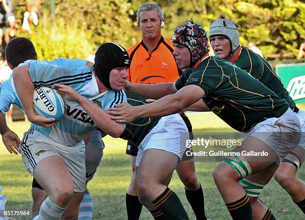 Alan Kesen of Argentina's under-20 national rugby team runs with the ball as a South African opponent tries to tackle him during a friendly match on...