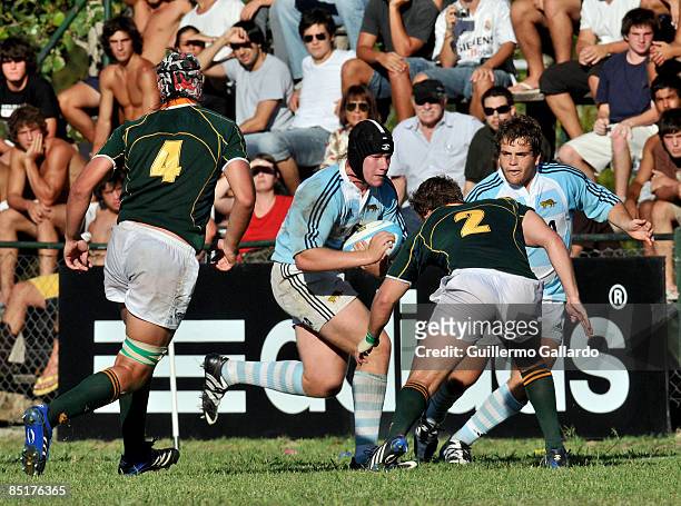 Alan Kesen of Argentina's under-20 national rugby team runs with the ball as a South African opponent tries to tackle him during a friendly match on...