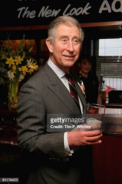 Prince Charles, Prince of Wales enjoys a pint of beer while he meets local people at The Viaduct Pub during his visit to Froncysyllte, winner of the...