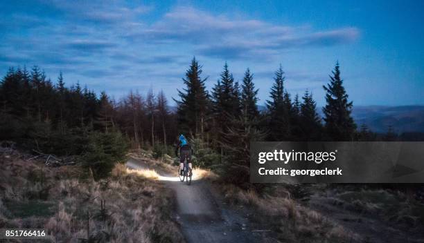 mountainbiken met verlichting in de schemering - hoofdlamp stockfoto's en -beelden