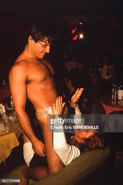 Un homme en maillot de bain chevauche une spectatrice dans le public d'un club érotique pour femmes en mars 1992 à Caracas, Venezuela.