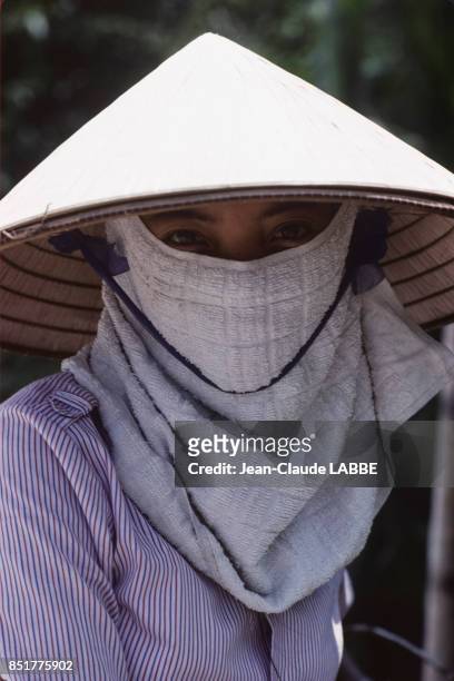 Jeune femme au visage protégé par un masque en janvier 1991 à Hô-Chi-Minh-Ville, Vietnam.