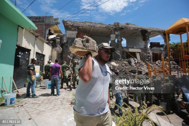 Volunteers help remove the debris from a collapsed building three days after the magnitude 7.1 earthquake jolted central Mexico killing more than 250...